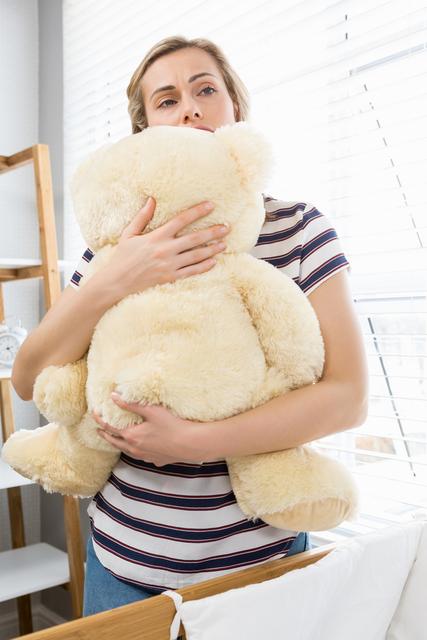 Depressed mother holding teddy bear - Download Free Stock Photos Pikwizard.com