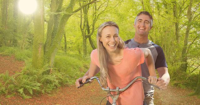 happy couple riding bicycle in forest - Download Free Stock Photos Pikwizard.com