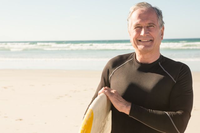 Portrait of smiling man carrying surfboard - Download Free Stock Photos Pikwizard.com