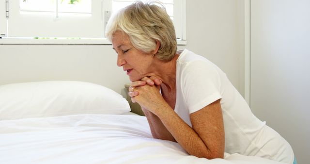 Mature woman praying on her bed  - Download Free Stock Photos Pikwizard.com