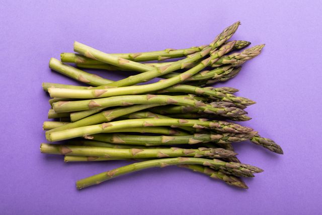 Directly above shot of asparagus on purple background, copy space - Download Free Stock Photos Pikwizard.com
