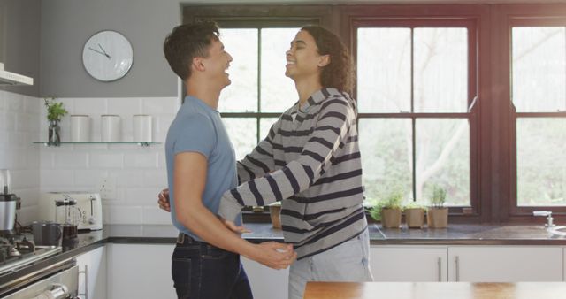 Happy diverse male couple smiling and dancing together in kitchen - Download Free Stock Photos Pikwizard.com