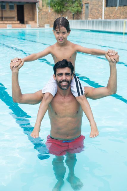 Father carrying son on shoulder in pool - Download Free Stock Photos Pikwizard.com