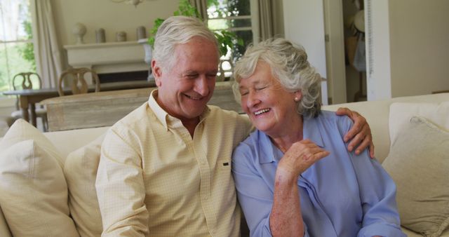 Portrait of smiling caucasian senior couple hugging each other while sitting on the couch at home - Download Free Stock Photos Pikwizard.com