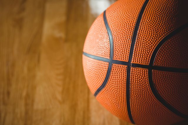 Extreme close up of orange basketball on floor in court