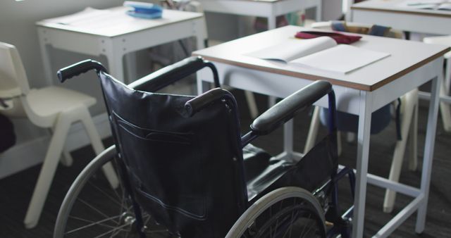 Image of empty wheelchair standing at desk in classroom - Download Free Stock Photos Pikwizard.com