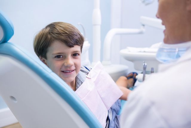 Portrait of cute boy sitting on dentist chair by dentist - Download Free Stock Photos Pikwizard.com