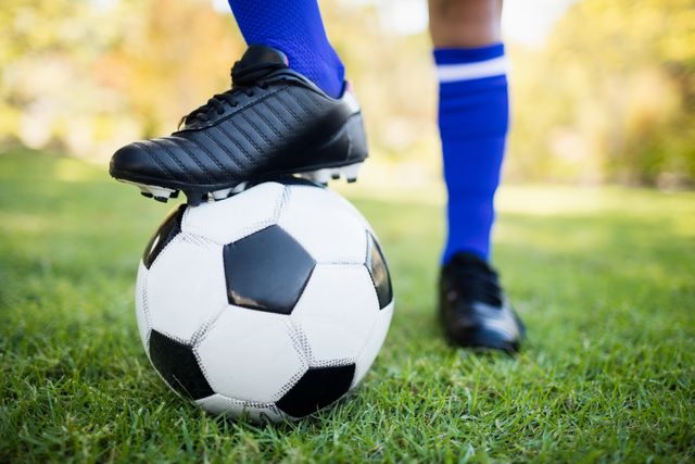 Close up view of balloon under football boots in park - Download Free Stock Photos Pikwizard.com