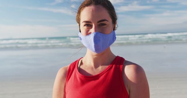 Portrait of caucasian woman wearing face mask at the beach. holiday, freedom and leisure time outdoors.