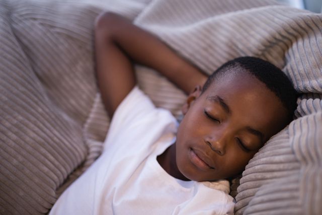 High angle view of boy sleeping on couch at home