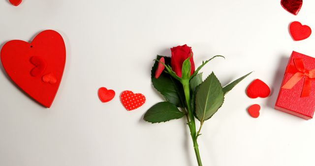 Red roses, gift boxes and heart shape of confetti on white surface in circle formation - Download Free Stock Photos Pikwizard.com