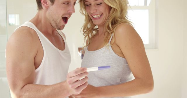 A joyful couple celebrates a positive pregnancy test result. - Download Free Stock Photos Pikwizard.com