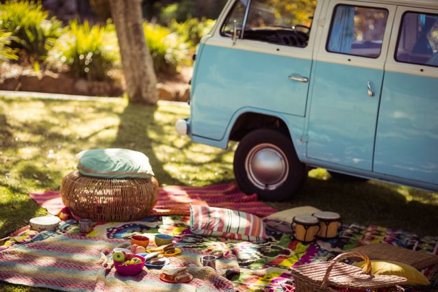 Picnic accessories scattered on blanket next to campervan in park - Download Free Stock Photos Pikwizard.com