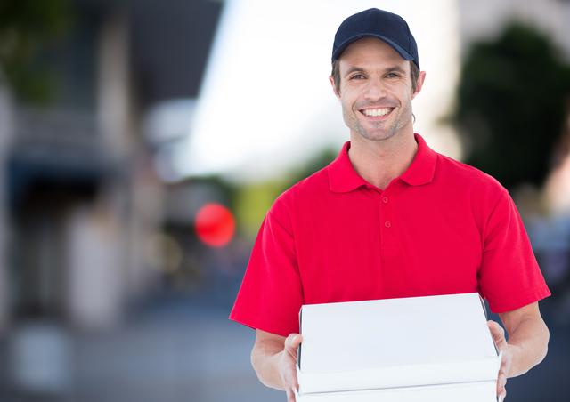 Happy deliveryman with pizza boxes in the city - Download Free Stock Photos Pikwizard.com
