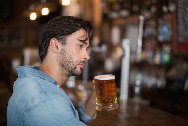 Man looking away while drink beer at pub - Download Free Stock Photos Pikwizard.com