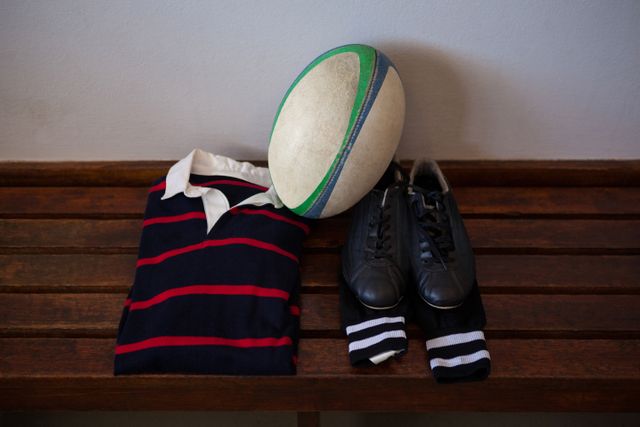Rugby ball and clothes with shoes on bench in locker room - Download Free Stock Photos Pikwizard.com