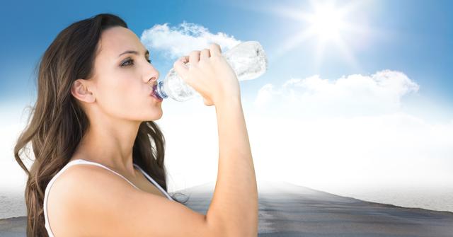 Female runner drinking on road against sky and sun - Download Free Stock Photos Pikwizard.com