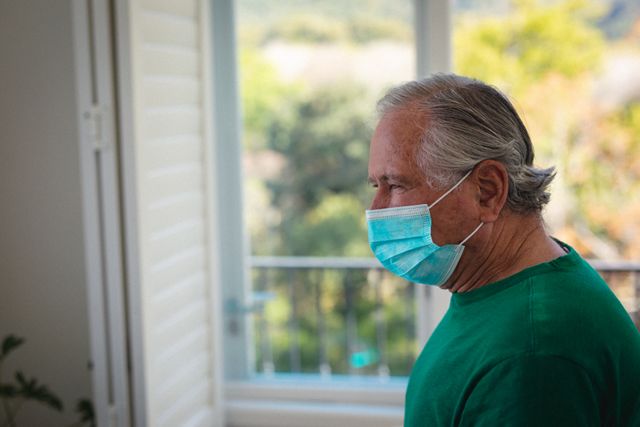 Side view of caucasian senior man wearing a face mask at home - Download Free Stock Photos Pikwizard.com