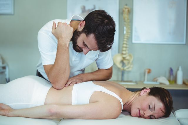 Physiotherapist giving back massage to a woman - Download Free Stock Photos Pikwizard.com