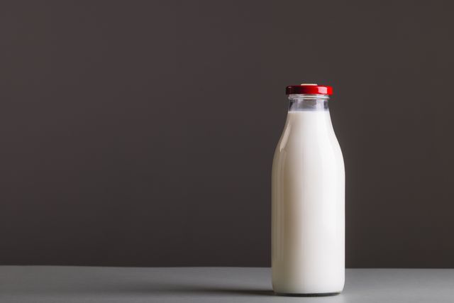 Close-up of milk bottle against gray background with copy space - Download Free Stock Photos Pikwizard.com