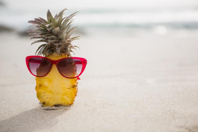 Halved pineapple and a sunglass kept on the sand - Download Free Stock Photos Pikwizard.com