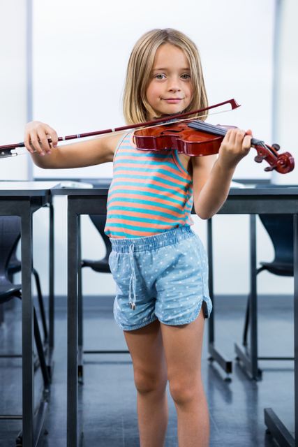 Portrait of girl playing violin in classroom - Download Free Stock Photos Pikwizard.com