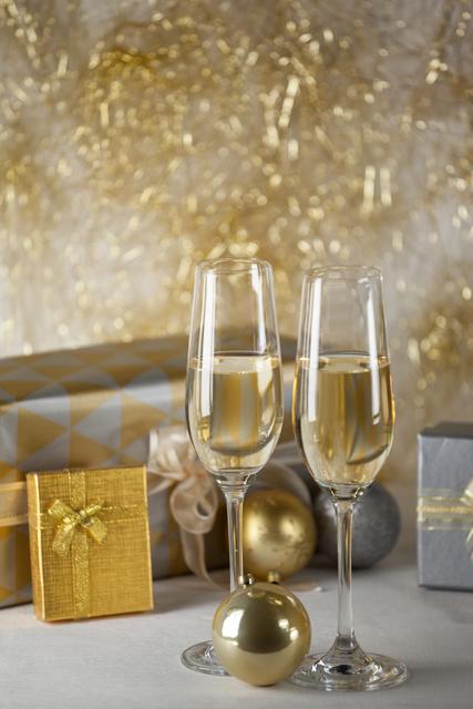 Two champagne flutes and Christmas gifts - Download Free Stock Photos Pikwizard.com