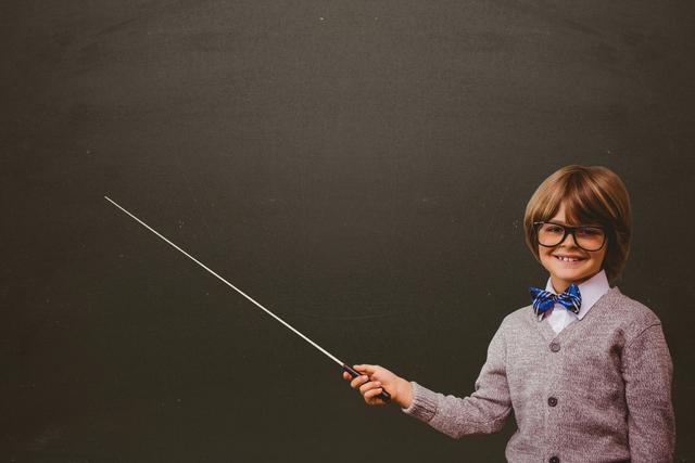 Cute student holding stick against black board - Download Free Stock Photos Pikwizard.com