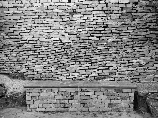 a brick wall with a bench - Download Free Stock Photos Pikwizard.com
