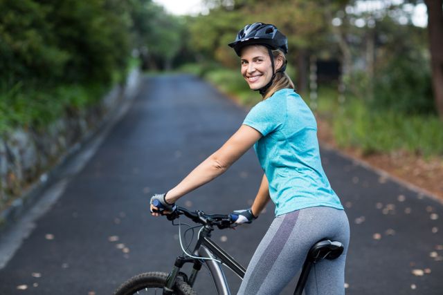 Woman standing with mountain bike on the open road - Download Free Stock Photos Pikwizard.com