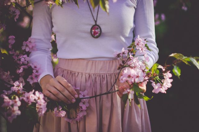 Woman Wearing White Long Sleeve Shirt and Beige Skirt Holding Pink Petaled Flower - Download Free Stock Photos Pikwizard.com