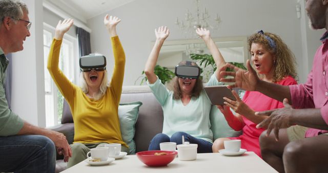 Image of happy diverse female and male senior friends using vr headset and having fun. retirement lifestyle, spending quality time with friends and technology.