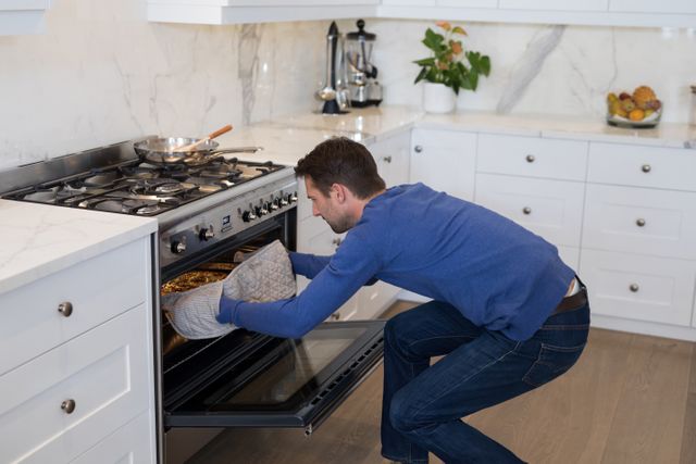 Man putting pizza into oven in kitchen - Download Free Stock Photos Pikwizard.com