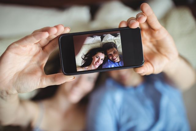 Romantic couple relaxing on bed and taking a selfie - Download Free Stock Photos Pikwizard.com