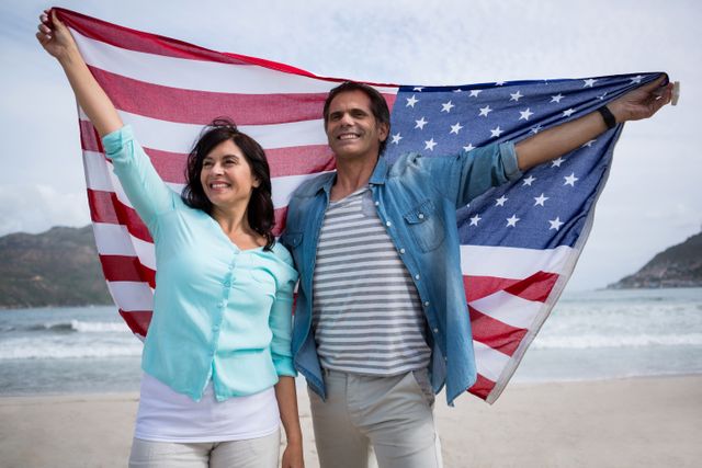 Couple holding american flag on beach during winter