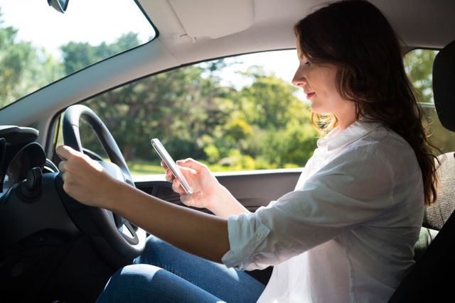 Woman using mobile phone while driving a car - Download Free Stock Photos Pikwizard.com