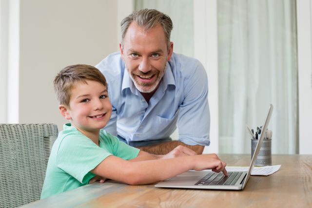 Father and son using laptop at desk - Download Free Stock Photos Pikwizard.com