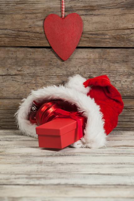 Red Christmas bauble and gift kept in santa hat during Christmas time