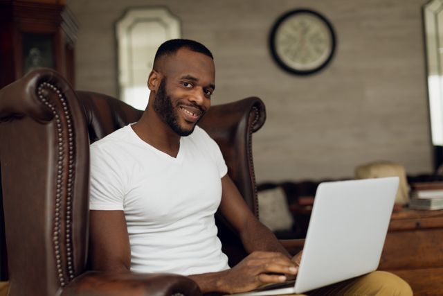 Man smiling and sitting while using laptop - Download Free Stock Photos Pikwizard.com