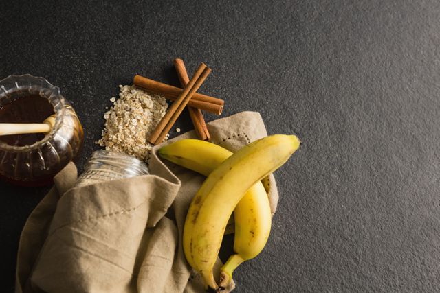 Honey, banana, oatmeal, cinnamon sticks on black background - Download Free Stock Photos Pikwizard.com