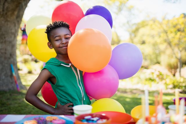 Cute boy smiling and posing next to balloon during a birthday party - Download Free Stock Photos Pikwizard.com