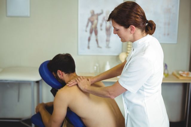 Physiotherapist giving back massage to a patient - Download Free Stock Photos Pikwizard.com