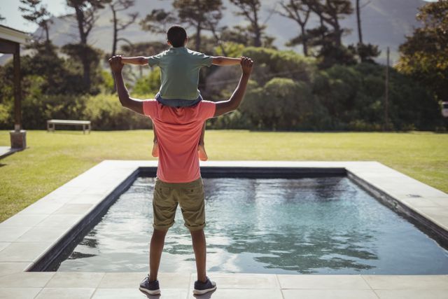 Father carrying son on shoulders near poolside - Download Free Stock Photos Pikwizard.com