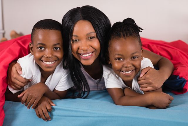 Portrait of smiling woman with children lying on bed - Download Free Stock Photos Pikwizard.com