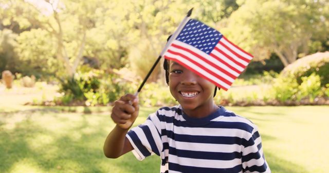 Slow motion portrait of happy boy waving American Flag at park - Download Free Stock Photos Pikwizard.com