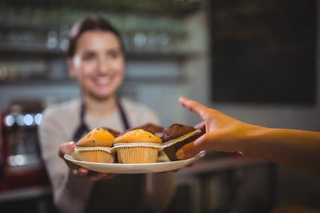 Waitress serving a plate of cupcake to customer - Download Free Stock Photos Pikwizard.com