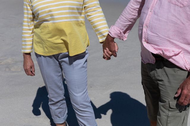Mid section of senior caucasian couple holding each others hands at the beach - Download Free Stock Photos Pikwizard.com