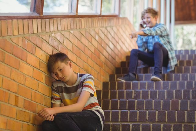 School friend bullying a sad boy in school corridor - Download Free Stock Photos Pikwizard.com