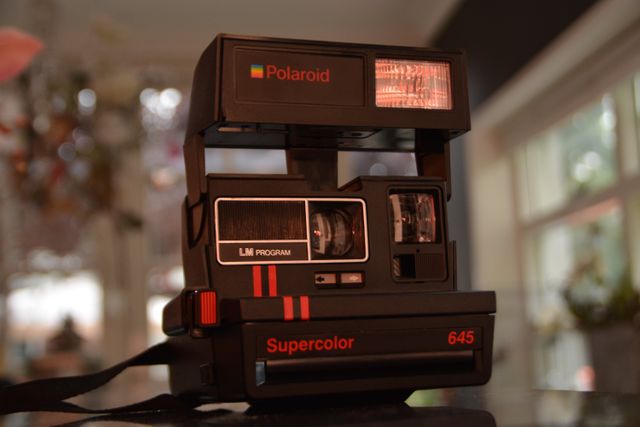 Black Polaroid Supercolor Camera on Black Table - Download Free Stock Photos Pikwizard.com