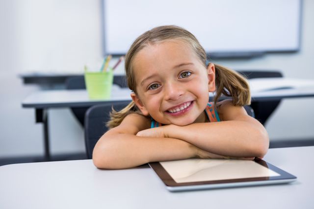 Portrait of happy girl with digital tablet in classroom - Download Free Stock Photos Pikwizard.com